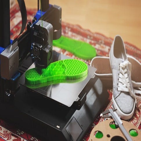 3D-printer makes bright green shoe sole from flexible plastic filament - Image Credit: Shutterstock/R_Boe